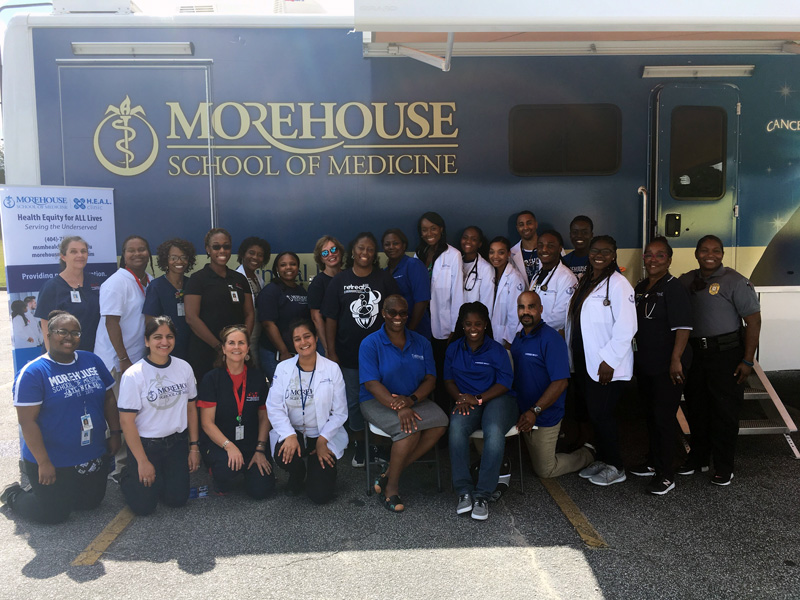 HEAL Clinic members in front of the vehicle