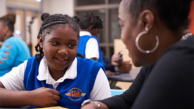 a young woman wearing a blue vest smiles